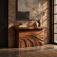 Console table with rough slab top and dune carved base in an industrial loft entryway with exposed brick
