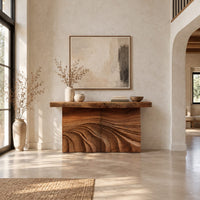Console table with rough slab top and dune carved base in a bright open plan entryway
