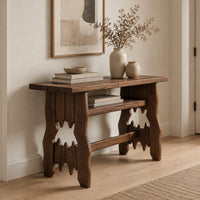 Rustic plank top console table with cutout slab legs and two cross rails in a Scandinavian entryway with white walls