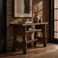 Rustic plank top console table with cutout slab legs and two cross rails in an industrial loft entryway with exposed brick