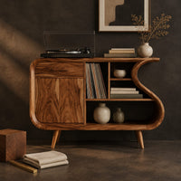 Corner detail of record player stand with an s shaped side, one door and open shelves beside wood, brass and linen samples