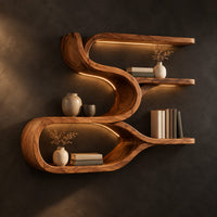 Sculpted wood shelf with an open loop cubby and three narrow ledges in a dark studio against a charcoal plaster wall