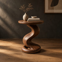 Side table with a twisting pedestal and a coiled loop base in a dark studio against a charcoal plaster wall