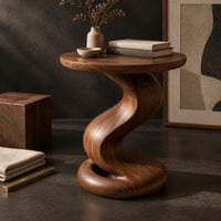 Corner detail of side table with a twisting pedestal and a coiled loop base beside wood, brass and linen samples
