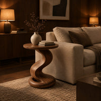 Side table with a twisting pedestal and a coiled loop base in an evening living room with walnut wall paneling