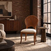 Dining chair with a carved fan shaped back and cushioned seat in an industrial loft living room with exposed brick