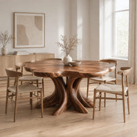 Dining table with a scalloped edge top and a flared branching pedestal in a Scandinavian dining room with white walls