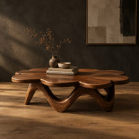Petal edged coffee table on a rolling arched base in a dark studio against a charcoal plaster wall