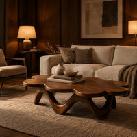 Petal edged coffee table on a rolling arched base in an evening living room with walnut wall paneling