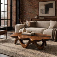 Petal edged coffee table on a rolling arched base in an industrial loft living room with exposed brick
