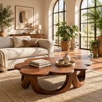 Scalloped coffee table on a ring of arched wooden panels in a bright living room with arched windows and plants