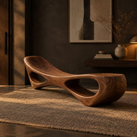 Scooped seat bench with two open oval cutouts in its body in a dark entryway at golden hour