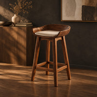 Bar stool with a scooped wooden seat and a cream cushion, three-quarter view showing the grain