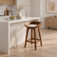 Bar stool with a scooped wooden seat and a cream cushion in a Scandinavian kitchen with white walls
