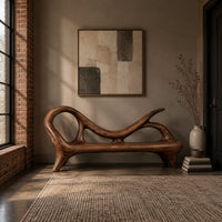 Bench with a looping scroll back and a flat seat on splayed legs in an industrial loft entryway with exposed brick