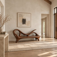 Bench with a looping scroll back and a flat seat on splayed legs in a bright open plan entryway