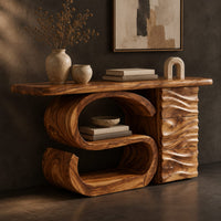 Corner detail of console table with a large scroll base and a wave carved side column beside wood, brass and linen samples