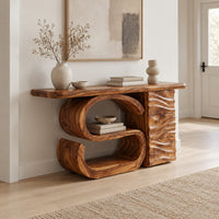 Console table with a large scroll base and a wave carved side column in a Scandinavian entryway with white walls