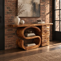 Console table with a large scroll base and a wave carved side column in an industrial loft entryway with exposed brick