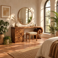 Makeup vanity desk with a spiral scroll leg and a three drawer cabinet in a bright bedroom with arched windows and plants