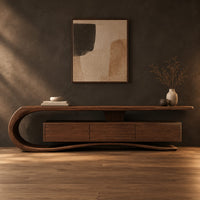 Tv stand with a sweeping scroll end and a three panel cabinet in a dark studio against a charcoal plaster wall