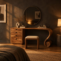 Makeup vanity with four drawers and a sweeping top ending in a scroll leg in a dark bedroom at golden hour