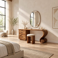 Makeup vanity with four drawers and a sweeping top ending in a scroll leg in a bright open plan bedroom