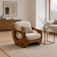 Low accent chair with a sculpted wood shell and circular side openings in a Scandinavian living room with white walls