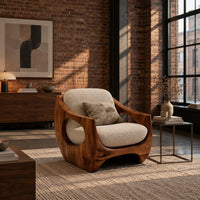Low accent chair with a sculpted wood shell and circular side openings in an industrial loft living room with exposed brick