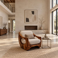 Low accent chair with a sculpted wood shell and circular side openings in a bright open plan living room