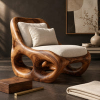 Corner detail of sculpted wood accent chair with open loops in the base and loose cushions beside wood, brass and linen samples