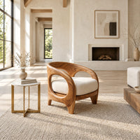 Barrel shaped chair with open oval cutouts and a cream seat cushion in a bright open plan living room