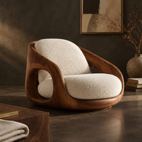 Corner detail of barrel shaped wood chair with oval side openings and cream cushions beside wood, brass and linen samples