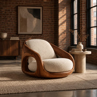 Barrel shaped wood chair with oval side openings and cream cushions in an industrial loft living room with exposed brick