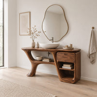 Freeform vanity cabinet with a swooping leg and a small drawer above open cubbies in a Scandinavian bathroom with white walls