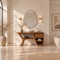 Freeform vanity cabinet with a swooping leg and a small drawer above open cubbies in a bright open plan bathroom