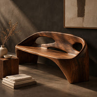 Corner detail of sculpted bench with a cutout back and swept side legs beside wood, brass and linen samples