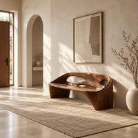 Sculpted bench with a cutout back and swept side legs in a bright open plan entryway