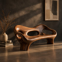 Sculpted wood bench with a low back and three oval openings, three-quarter view showing the grain