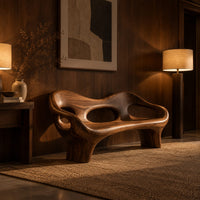 Sculpted wood bench with a low back and three oval openings in an evening entryway with walnut wall paneling