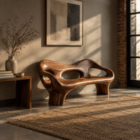 Sculpted wood bench with a low back and three oval openings in an industrial loft entryway with exposed brick