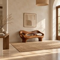 Sculpted wood bench with a low back and three oval openings in a bright open plan entryway