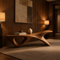 Long low wooden bench with a triangular open leg and a swept tapered end in an evening entryway with walnut wall paneling