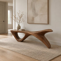Long low wooden bench with a triangular open leg and a swept tapered end in a Scandinavian entryway with white walls