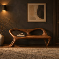 Wood bench with two oval back openings and looped legs in a dark entryway at golden hour