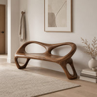 Wood bench with two oval back openings and looped legs in a Scandinavian entryway with white walls