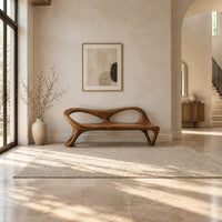 Wood bench with two oval back openings and looped legs in a bright open plan entryway