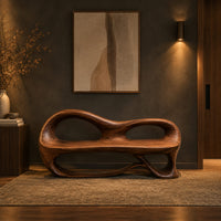 Bench with a sculpted back that has two oval openings in a dark entryway at golden hour