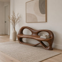 Bench with a sculpted back that has two oval openings in a Scandinavian entryway with white walls
