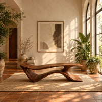Long low bench with a wave shaped plank seat on a swept base in a bright entryway with arched windows and plants